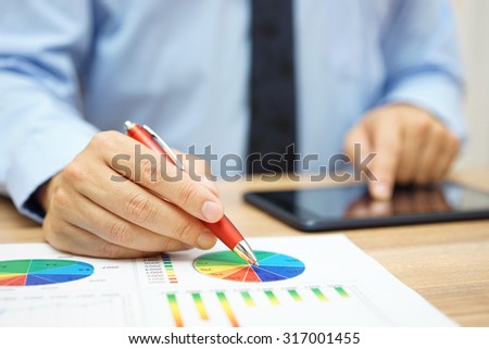 financial worker analyzing business data and working with tablet computer