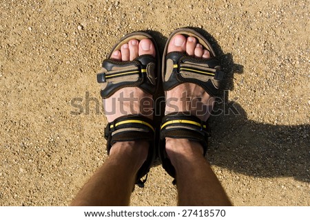 Photo of boy's foot on the sand ground