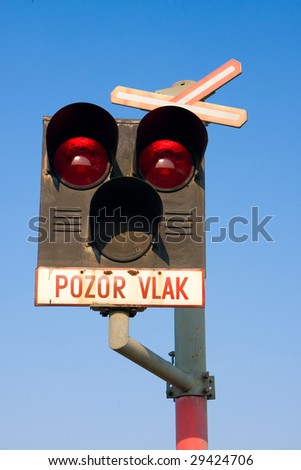 Red and blue train stop light with blue sky on the background
