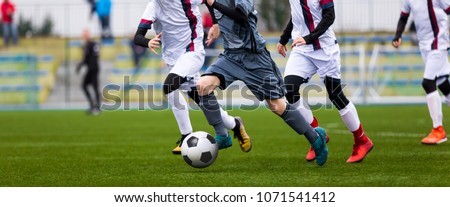 Junior Football Match. Soccer Game For Youth Players. Boys Playing Soccer Match on Football Pitch. Football Stadium and Grassy Field in the Background