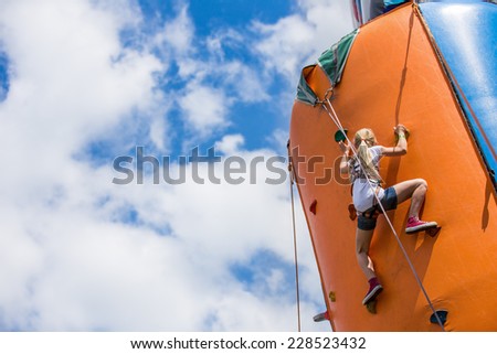 girl doing rock climbing on artificial climbing wall