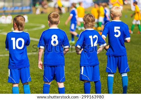 Children football soccer match. Team waiting on a bench. Ready to play soccer game
