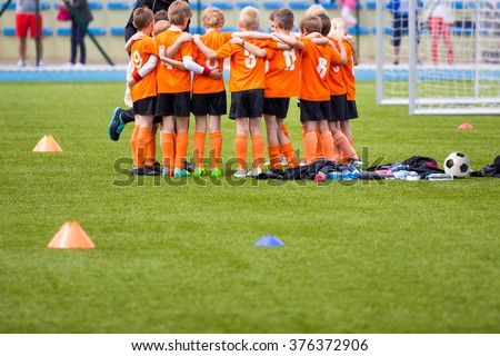 Youth soccer football team. Group photo. Soccer players standing together united. Soccer team huddle. Teamwork, team spirit and teammate example.