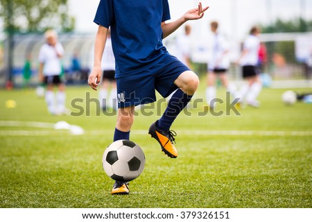 Teenagers Boys Playing Soccer Football Match. Young Football Players Running and Kicking Soccer Ball on a Soccer Pitch.