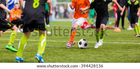 Young boys children in uniforms playing youth soccer football game tournament. Horizontal sport background.
