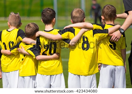 Young sport team with coach on sports field. Football; soccer; handball; volleyball; match for children. Youth sports team standing together. football soccer game. team work and penalty kick