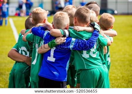 Young football soccer players in sportswear. Young sports team with football coach. Pep talk with coach before the final match. Soccer school tournament