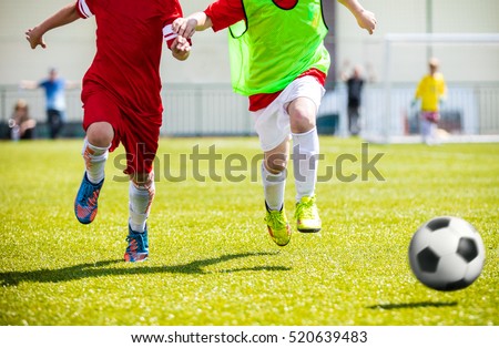 Football soccer match for children. Boys playing football game on a school tournament. Dynamic, action picture of kids competition during playing football. Sport background image