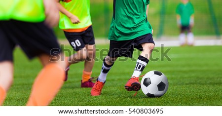 Kids Playing Football Soccer Game on Sports Field. Boys Play Soccer Match on Green Grass. Youth Soccer Tournament Teams Competition. Running Youth Football Players