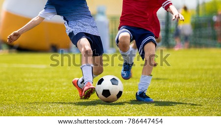 Young Soccer Players Competition. Boys Kicking Football Ball. Soccer Youth Teams Play Outdoor Tournament. Soccer Stadium in the Background