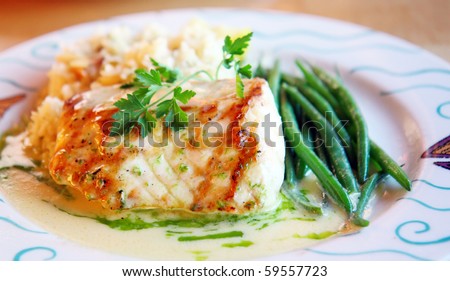 Platter of perfectly grilled sturgeon fish with sauce of white wine and side of green beans