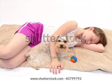 Beautiful young girl takes a nap with her dog, while pooch keeps watch