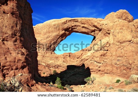 Window of sandstone rock forms arch or bridge in Utah desert