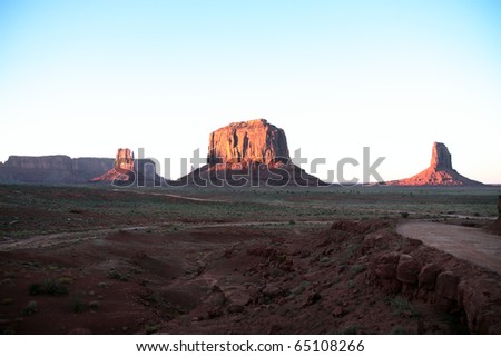 Rock formations in Monument Valley Navajo Tribal Park in Arizona lit by the setting sun