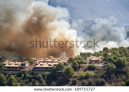 Fire burning mountain forest and village, danger for the houses