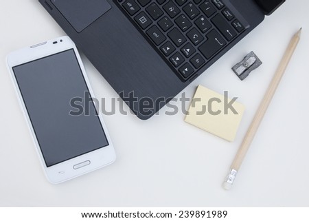 Workspace with laptop, mobile, clips, pencil, post it over white background