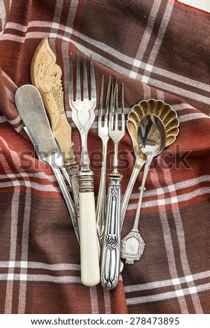 Old and vintage cutlery, spoon, fork and knife in a brown textile