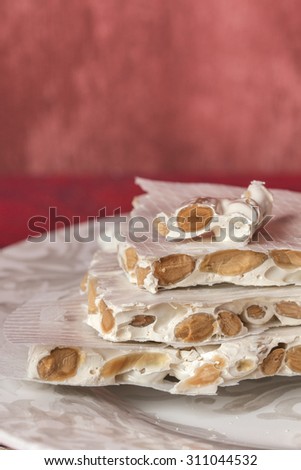 Turron, typical Spanish Christmas dessert over red background with copy space