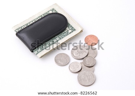 A leather money clip stuffed with dollar bills with assorted change on the side. Isolated on a white background.