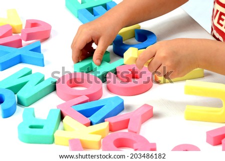 Child\'s hands playing with alphabet blocks