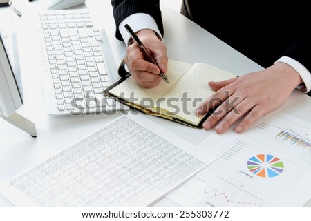 Business person writing on personal organizer