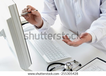 Doctor explaining while looking at pc monitor
