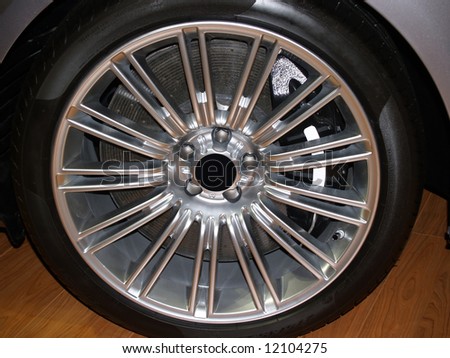 Close up of an alloy wheel of an exotic sports car showing detail of 8 piston brake calipers and carbon ceramic rotor.