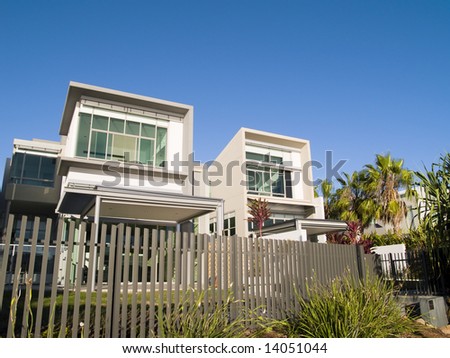 Duo of Modern architecturally designed residences in an up-market estate with fence in foreground
