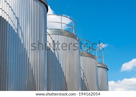 Silver silos and tank - industrial infrastructure in wide lens