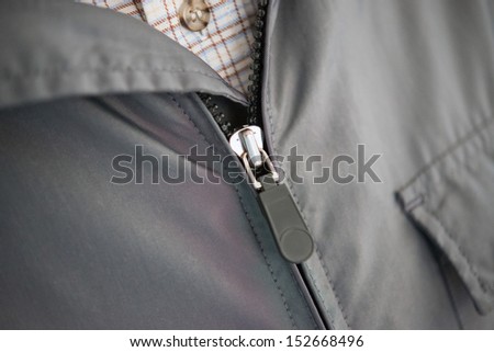 zipper of his jacket pulled over