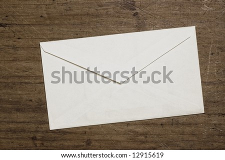 White envelope on wooden table, studio shot.