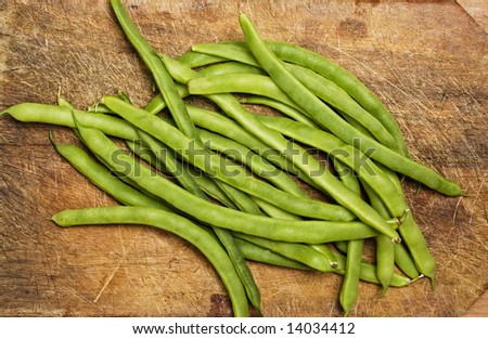 Green beans on wooden table, studio shot.