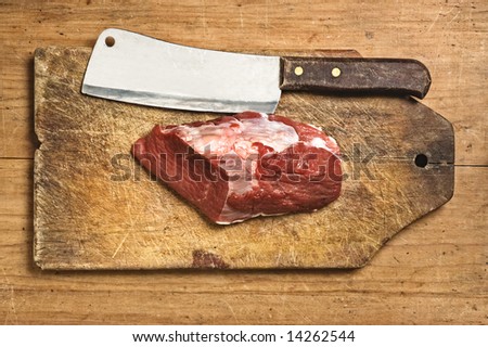 Butcher knife and raw meat, studio shot.