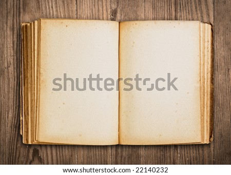 Vintage book, open, on old wooden table, with clipping path.