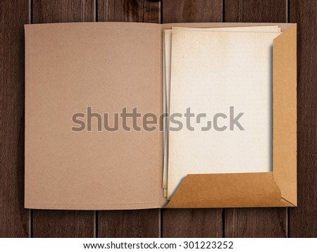 Old open folder on wooden table.