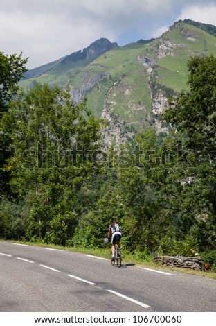 LARUNS,FRANCE- JUL 15:A lonely amateur cyclist climbing on the road to mountain pass Aubisque just before the passing of the peloton during the 13th stage of Le Tour de France on July 15 2011.