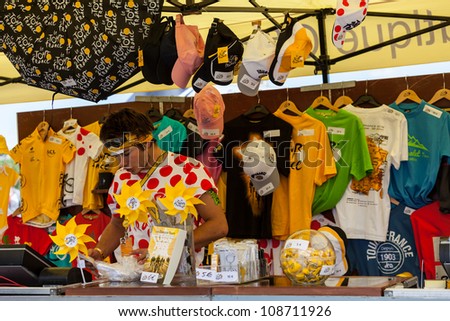 ROUEN, FRANCE - JULY 5 : A young man selling various promotional items on the official Tour of France shop in Rouen during the stage 5 of Le Tour de France on July 5, 2012.