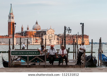 VENICE,ITALY-JULY 30:Unidentified gondoliers having a respite moment at the end of the workday near the Grand Canal on July 30, 2011.Gondola is a major mode of touristic transport in Venice, Italy.