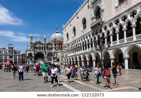VENICE,ITALY-JULY 28: Unidentified tourists walking in St Marco Square, in front of Doge\'s Palace on July 28 2011 in Venice, Italy. St Marco Square is the largest and most famous square in Venice.