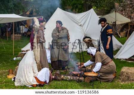 Nogent le Rotrou, France- May 19: A group of medieval people cooking outdoor near their traditional tents, during a historical reenactment festival on May 19,2012 in Nogent le Rotrou,France.