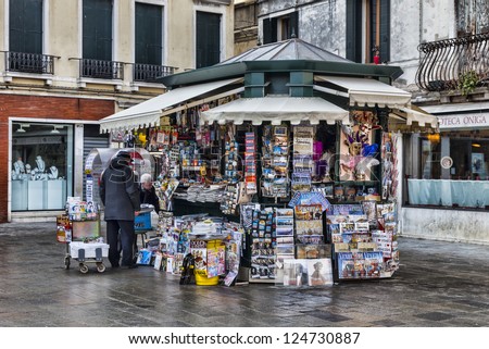VENICE-FEB 18:Unidentified two old men arranging a kiosk full of magazines and souvenirs in a town square on February 18, 2012 in Venice. In 2012 the Venice Carnival was held between 11- 21 February.