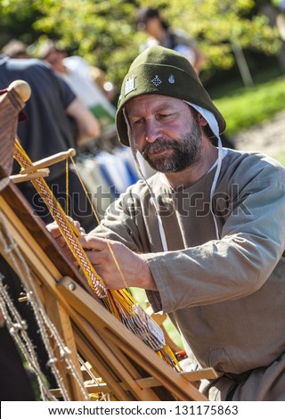 ARVILLE, FRANCE,MAY 23: Environmental portrait of a medieval leather-worker doing his job during a historical reenactment festival in Arville, France on May 23,2010.