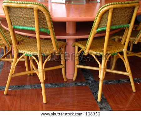 Two chairs and a part of a circular table in a coffee bar.