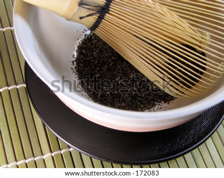 Bowl with green tea and traditional tea whisk on a bamboo floor-detail