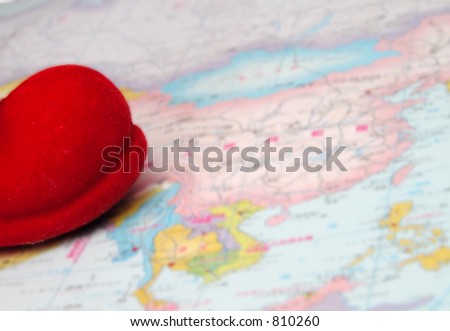 Santa\'s red boot tip on a world map.The boot is in focus and the map is blurry,out of focus.