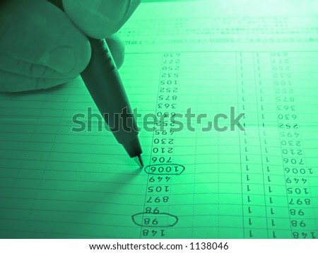 Close up of  hand with ball-pen analyzing a numbers column with dramatic colors