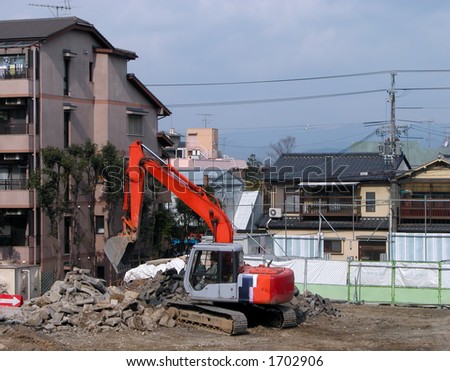 Working digger in an urban construction site