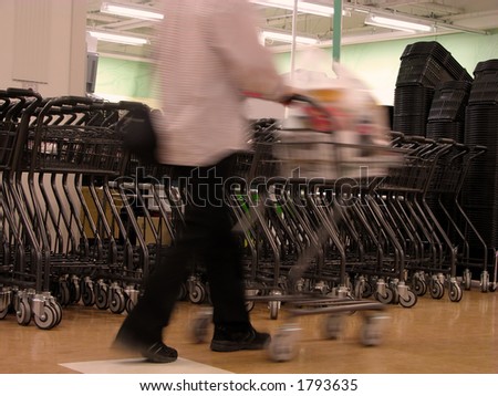 Motion blur abstract of a man with shopping cart in a supermarket