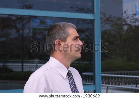 Profile of a businessman in front of a corporate building.
