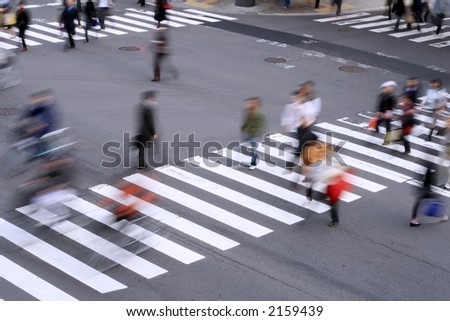 Aspect of a pedestrian cross with motion blurred aspect of the people.